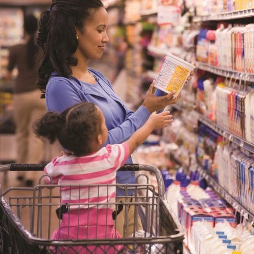 Mixed race woman shopping with daughter in grocery store