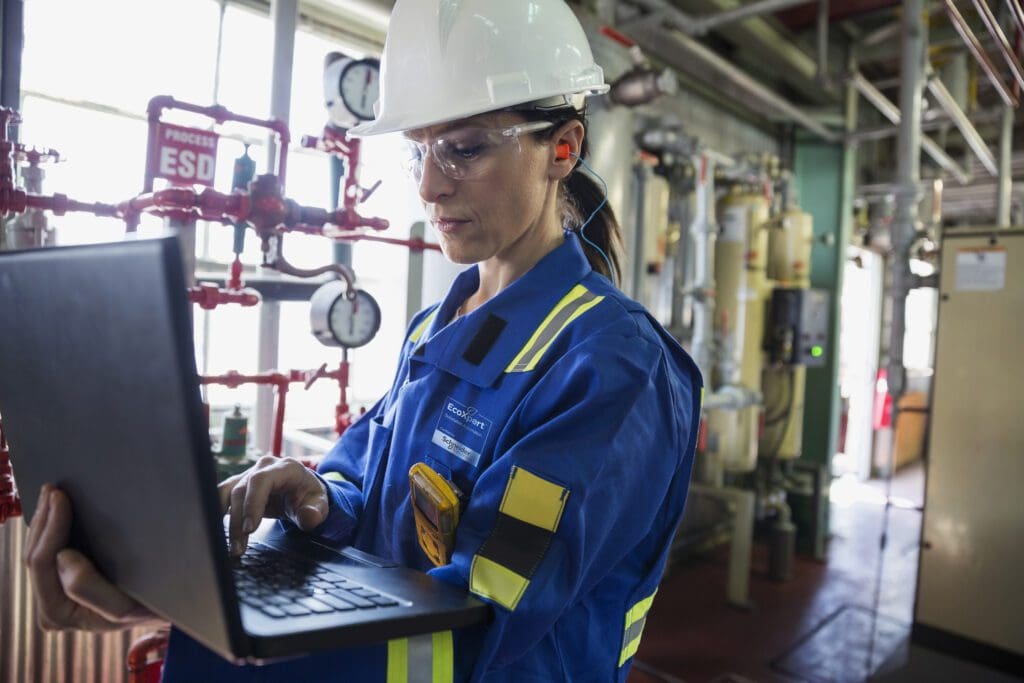 Female worker with laptop in gas plant